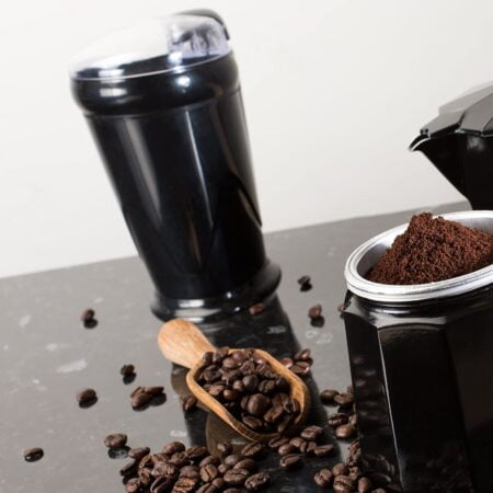 Electric coffee grinder and coffee beans on kitchen counter