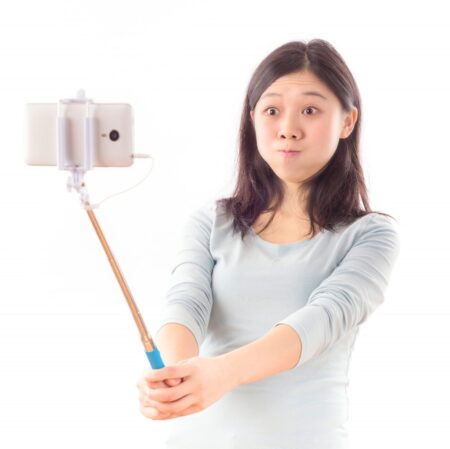 Happy girl using a selfie stick for autoportrait