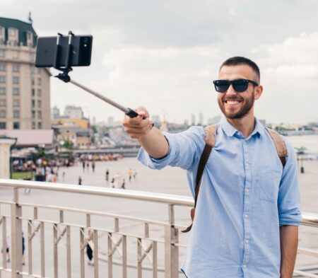 Happy tourist guy taking a selfie on the selfie stick