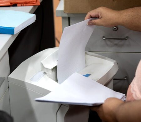 Secretary destroys documents using a paper shredder
