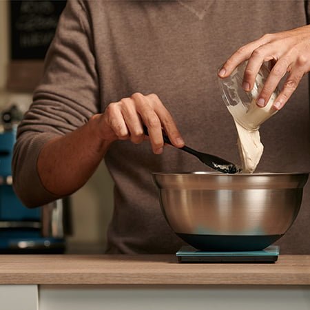 Digital kitchen scale with stainless steel bowl on countertop
