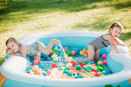 Kids playing with their toys in the garden inflatable swimming pool