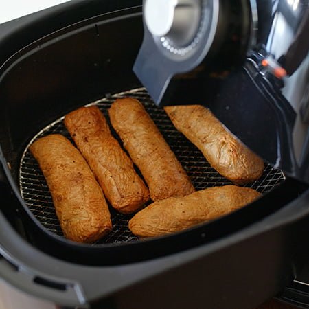 Airfryer basket with springrolls cooked to perfection