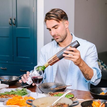 Opening a bottle of wine with an electric corkscrew